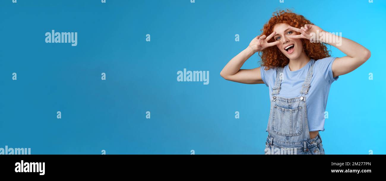 Sagen Sie cheeze hallo Sommer. Fröhlich charmant verspielt charismatisch Rotschopf nettes Mädchen lockig Frisur zeigen Zunge Frieden Sieg Geste Augen neigen Kopf Stockfoto