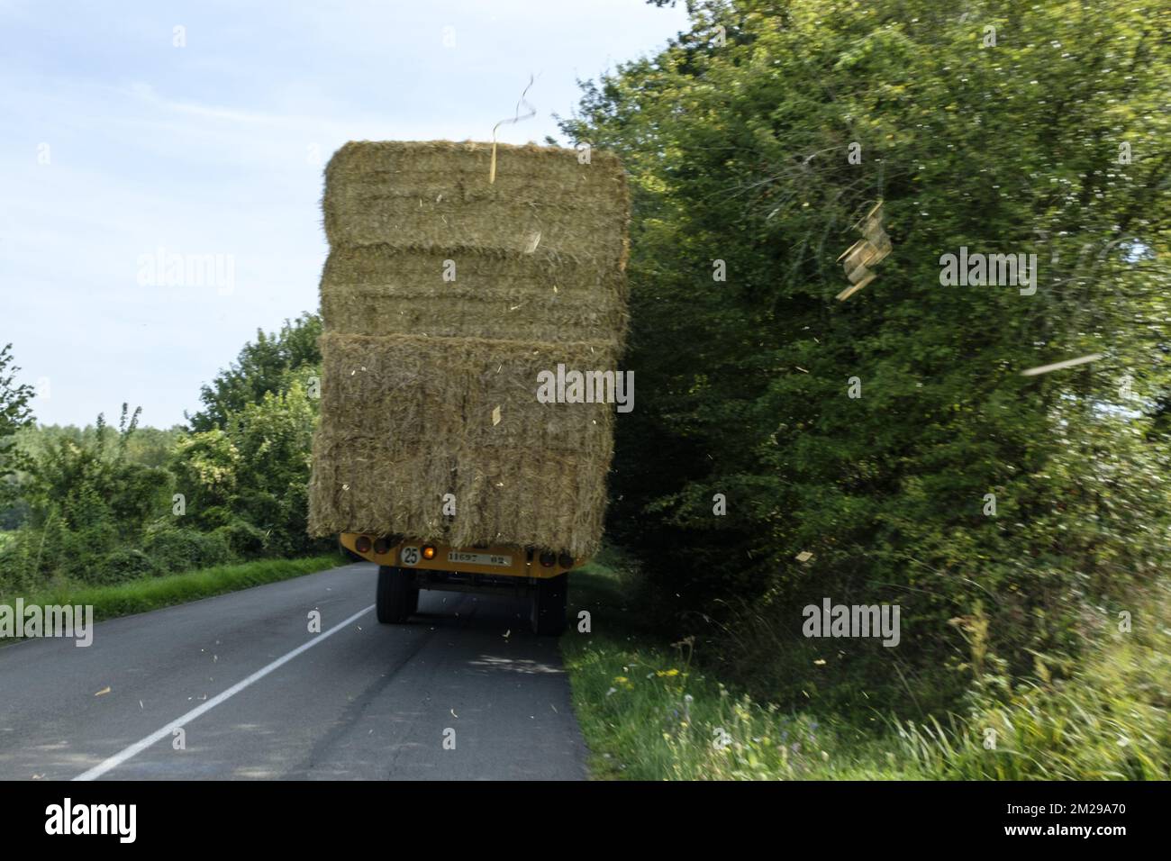 Traktor beladen mit Strohballen auf einer Landstraße | Tracteur Charge de bottes de paille sur une Route de Campagne 29/08/2017 Stockfoto