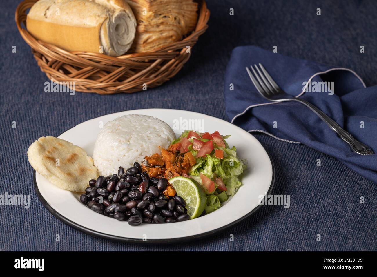 Casado, typisch Costa-ricanisches Gericht mit Reis, Bohnen und Gemüse auf blauer Tischdecke. Stockfoto