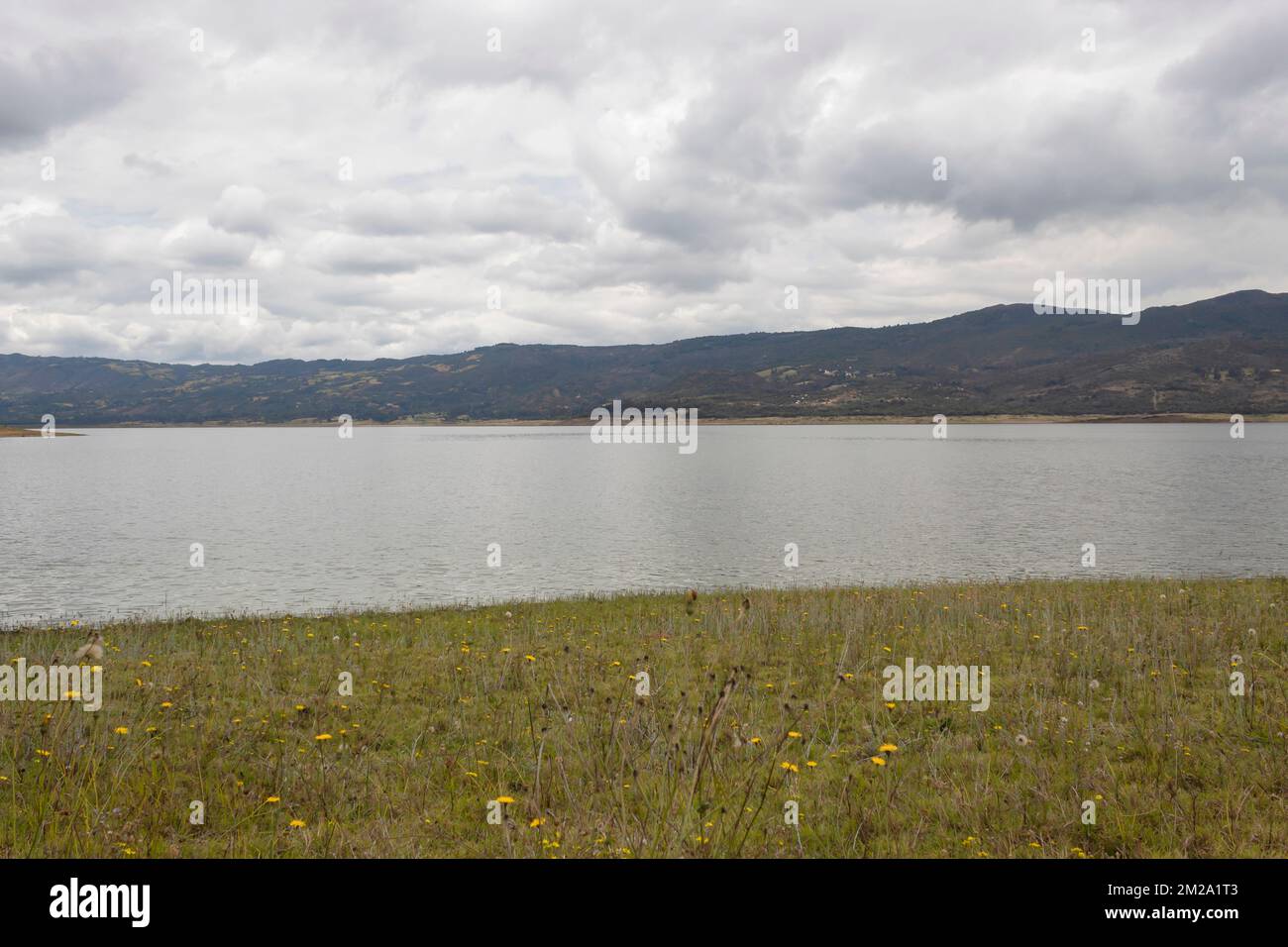 Guatavita-Tomine-See-Szene im Herbst, mit Bergen und wolkenlosem grauem Himmel Stockfoto