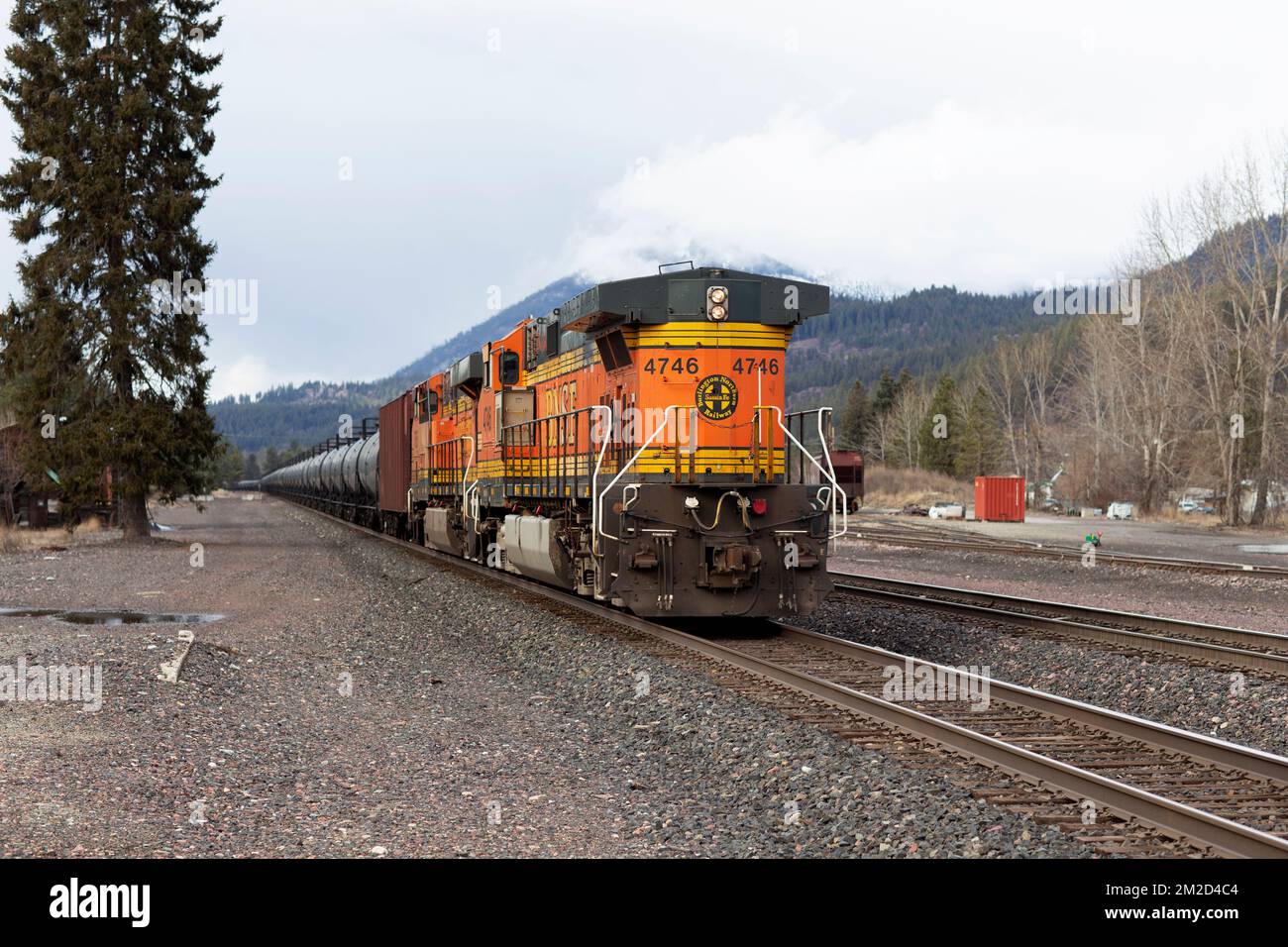 Die Tailing GE C44-9W Diesel-Schublokomotive eines BNSF Öltanker-Güterzugs, der die Gleise in Troy, Montana, entlangfährt. Stockfoto