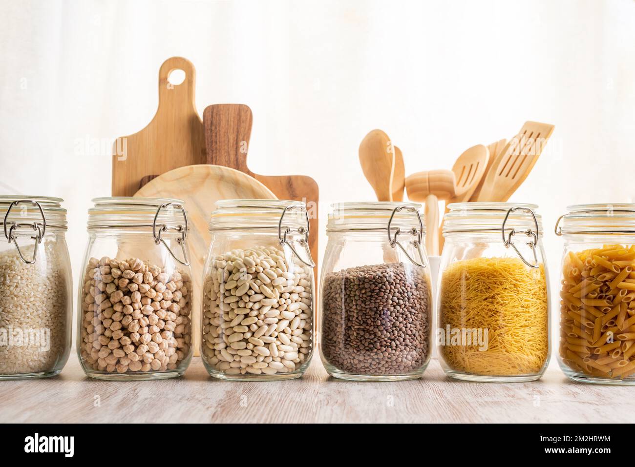 Kchenglser zur Aufbewahrung von Gemse und Pasta neben einigen  Schneidebrettern und einigen Kchenutensilien Stockfotografie - Alamy