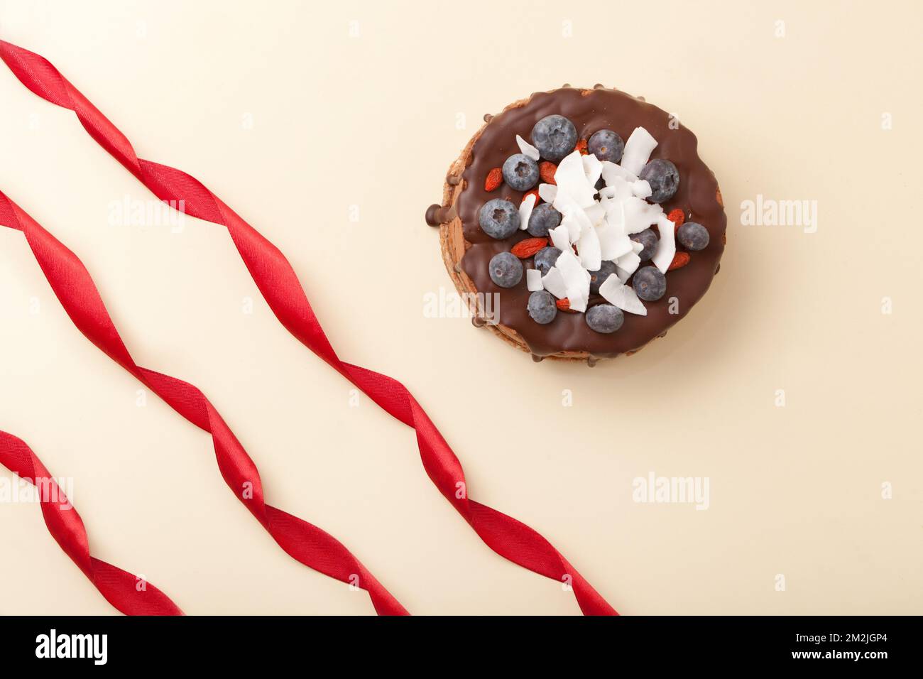 Schokoladenkuchen mit Kokosnuss. Vegane Torte mit Beeren. Roher Kuchen mit Nüssen, Brombeeren, Draufsicht. Stockfoto