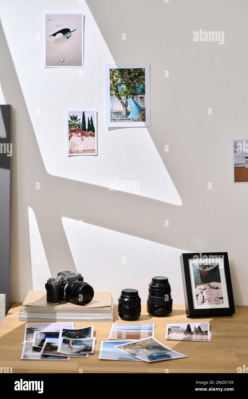 Vertikales Bild des Arbeitsplatzes eines Fotografen mit professionellen Fotos und einer Fotokamera im Studio Stockfoto