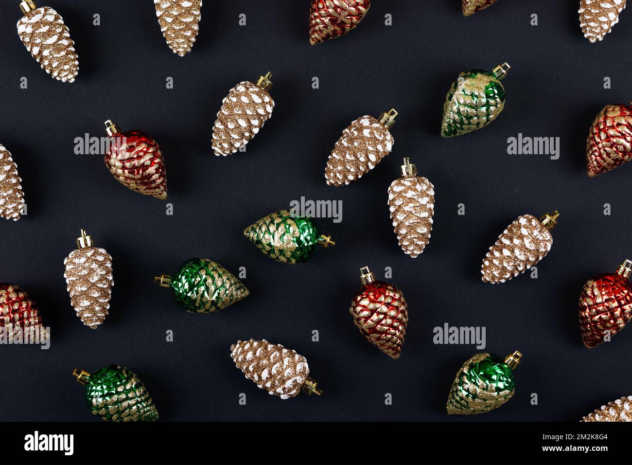 Abstrakte Hintergründe ihrer Weihnachtsdekorationen in Form von roten grünen und goldenen Pinienzapfen Stockfoto