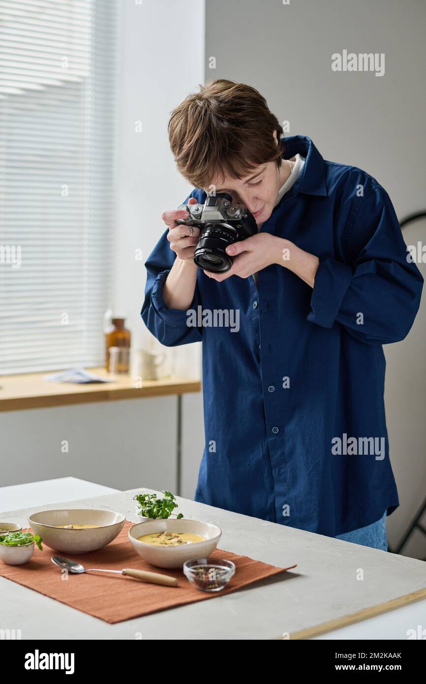 Professionelle Fotografin, die während ihrer Arbeit im Studio mit einer Digitalkamera Lebensmittel fotografiert Stockfoto