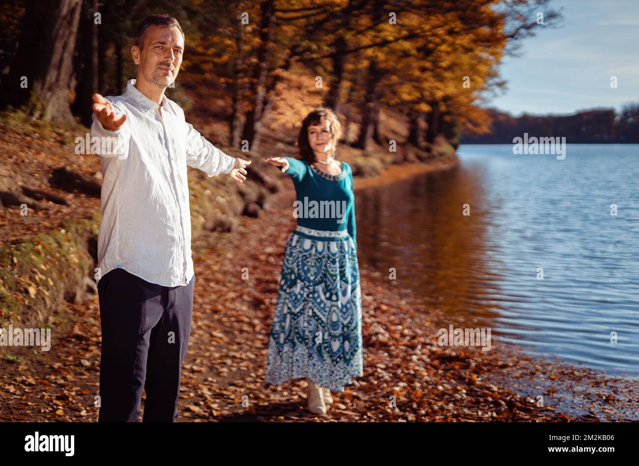 Ein romantisches Paar, das sich im Herbst am See verliebt hat. Stockfoto