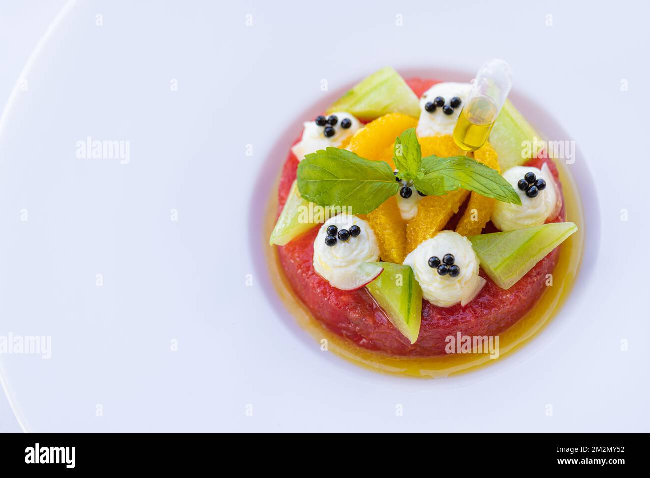 Tropischer Obstsalat mit Drachenfrucht, Wassermelone und Orangenpapaya auf weißem, elegantem Hintergrund. Gesunde Ernährung, Frühstück im Luxusresorthotel Stockfoto