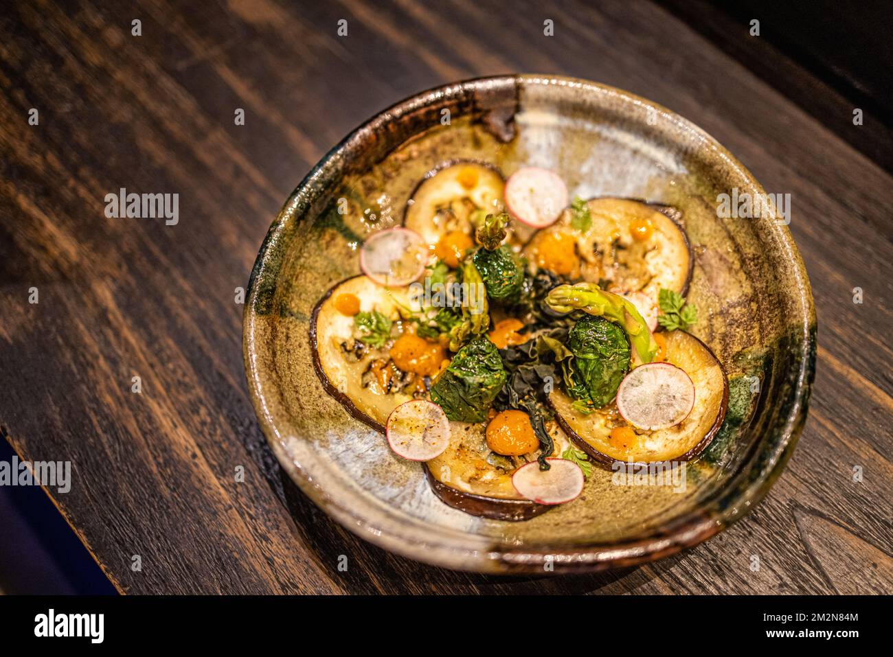 Gegrilltes buntes Gemüse, Auberginen, Zucchini, Pfeffer mit Gewürz und grünem Basilikum auf dem Servierbrett auf weißem Hintergrund, Draufsicht. Künstlerischer Luxus Stockfoto