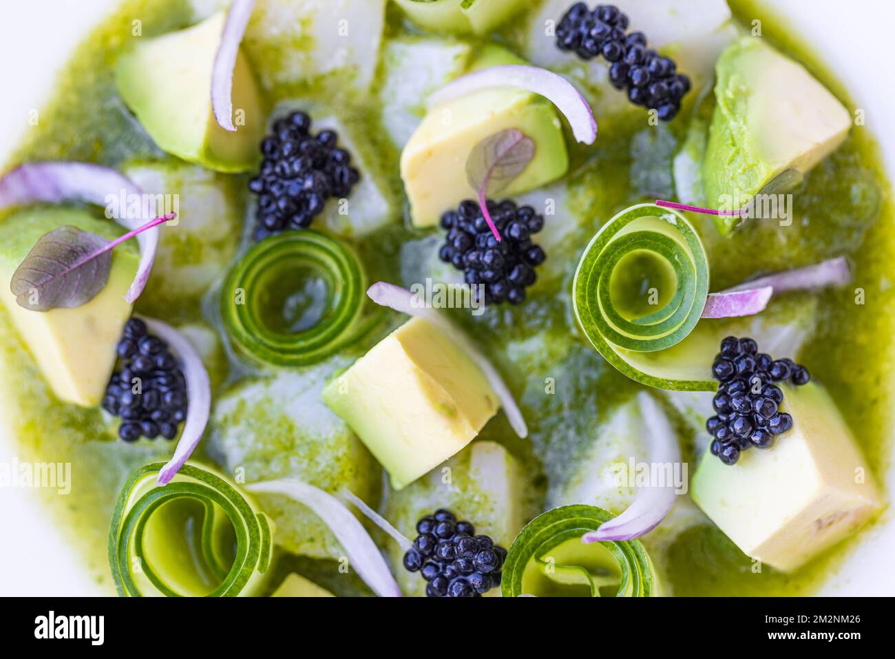 Gourmet-Luxus-Salat mit Blick von oben. Gurke mit Himbeere und Avocado. Blick auf Makroküche auf weißem Teller, köstliche Vorspeise oder vegane Salatvorlage Stockfoto