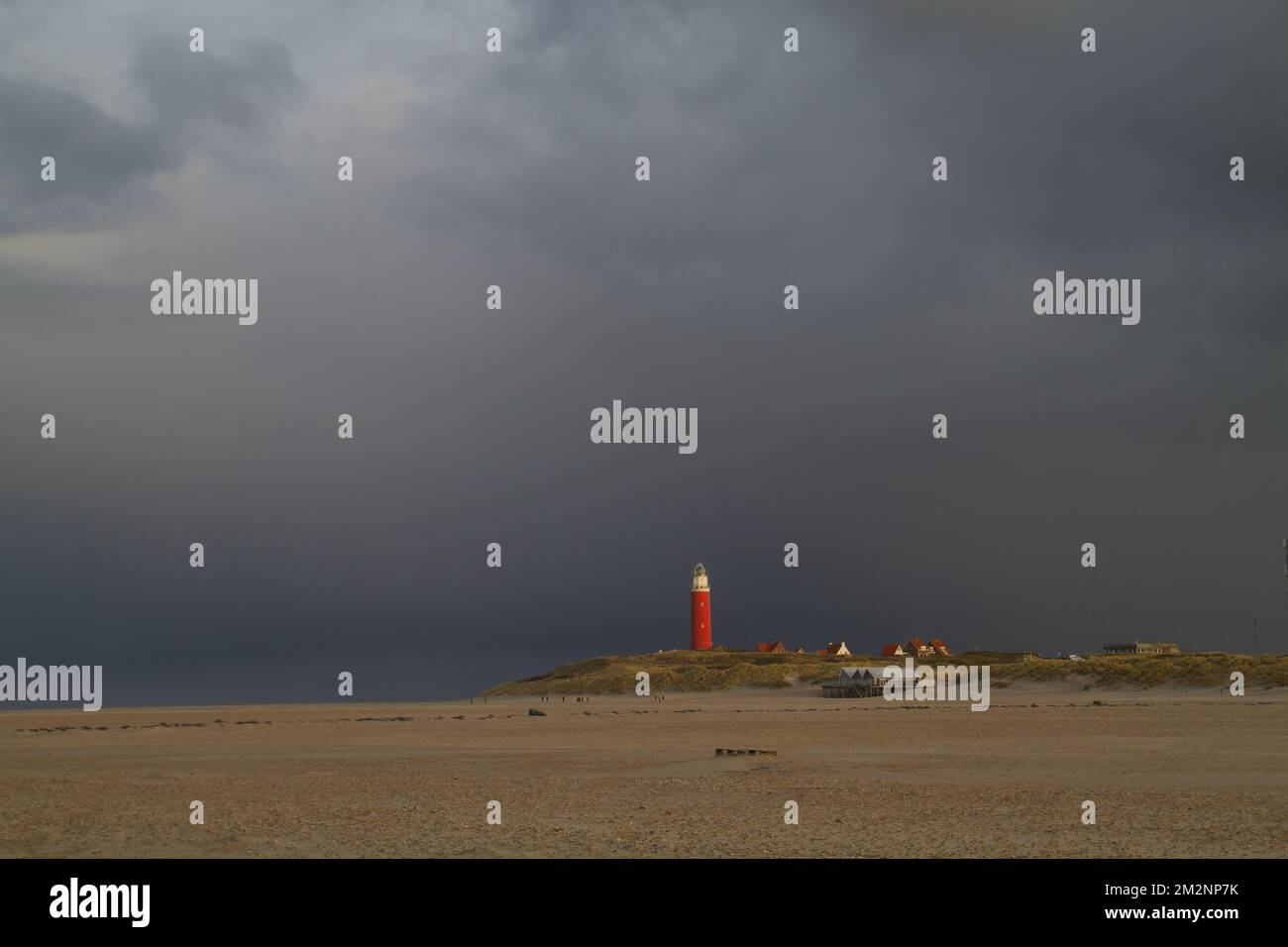 Leuchtturm, Regenwolken und breiter Strand Stockfoto