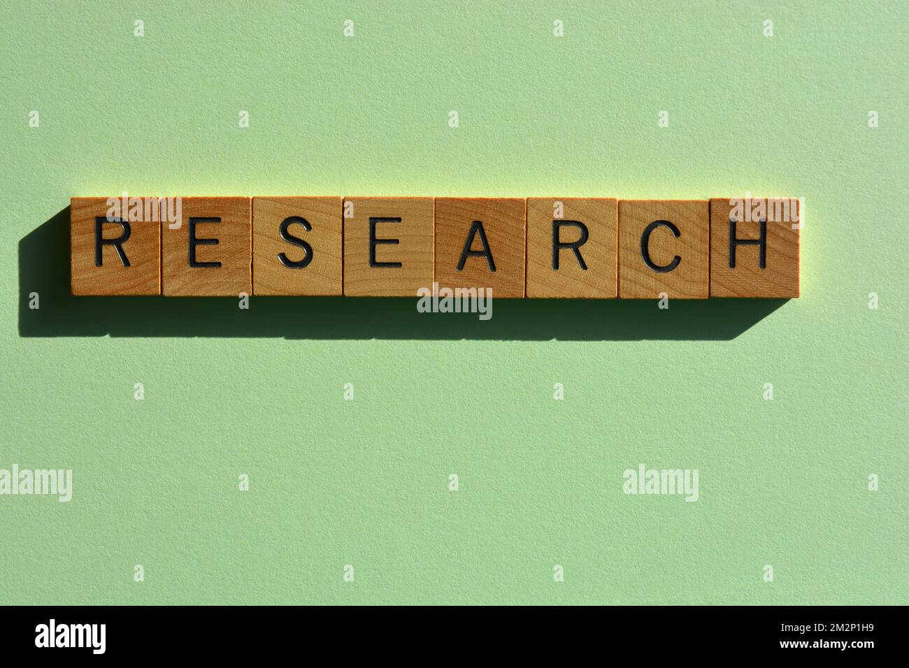 Forschung, Wort in Holzalphabet Buchstaben isoliert auf grünem Hintergrund Stockfoto