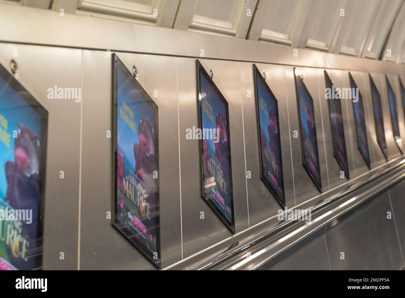 Reklametafeln, elektronische Werbetafeln, die an einer Rolltreppe einer Londoner U-Bahn-Station entlang laufen Stockfoto