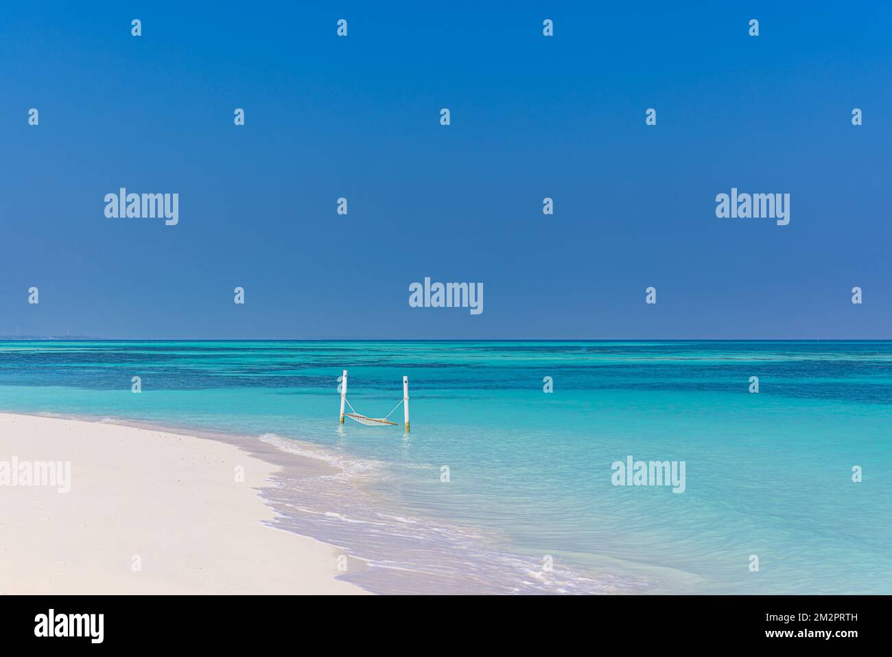 Luxusstrand. Ruhiger Hintergrund für Reisen. Sommerurlaub oder Urlaubskonzept am tropischen Strand, weißer Sand und herrlich über der WasserHängematte über der blauen Bucht Stockfoto