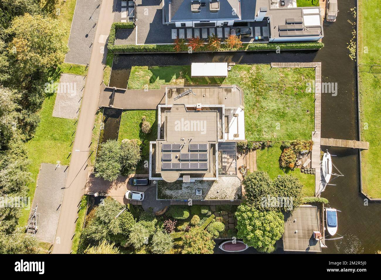 Ein Blick aus der Vogelperspektive auf ein Haus in der Mitte einer Wohngegend, von oben aufgenommen und die Umgebung dargestellt Stockfoto