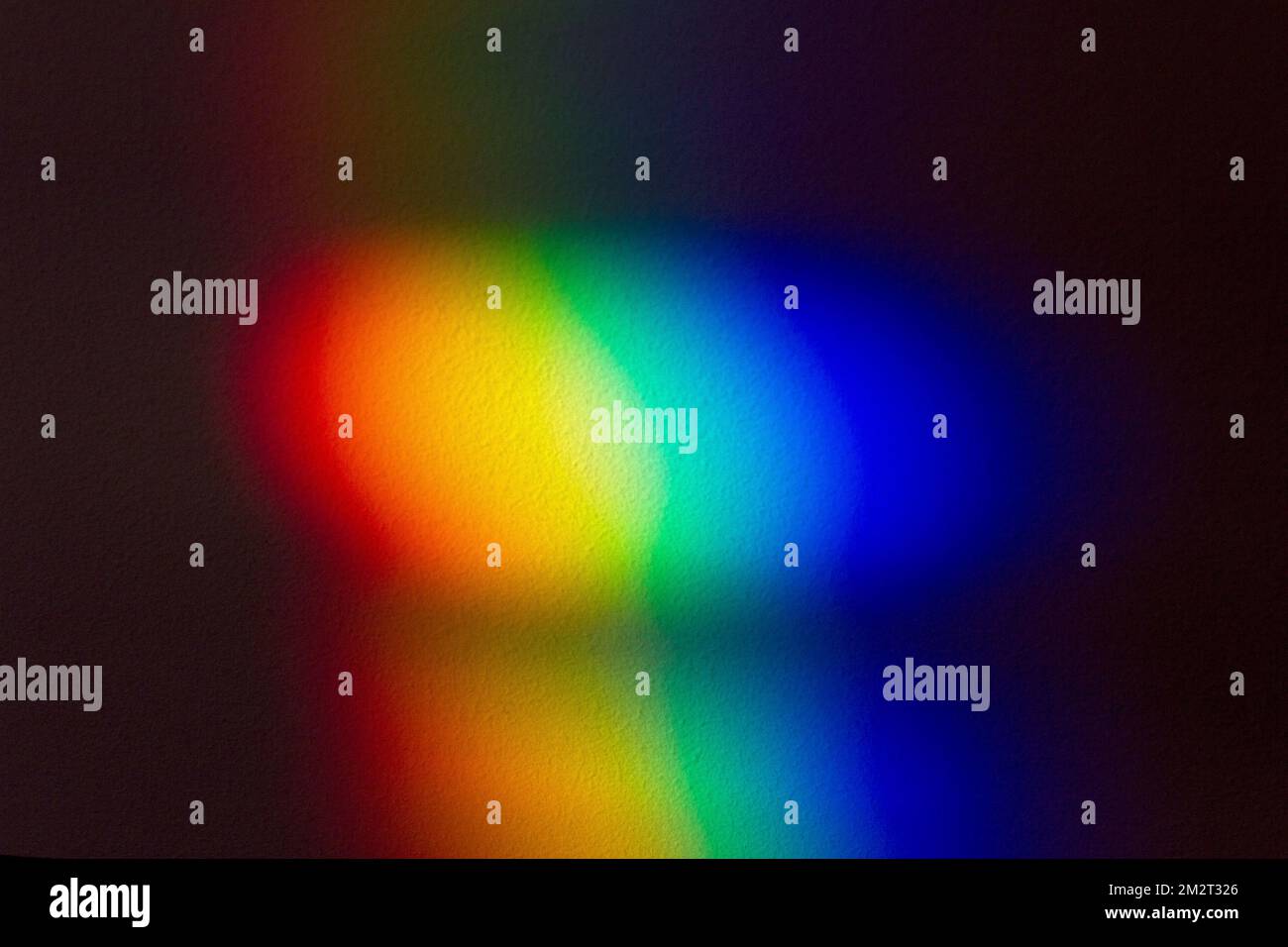 Regenbogen-Farbspektrum-Effekt an der Wand. Lichtstreuung nach dem Aufprall des Glasobjekts auf eine dunkle Wand. Stockfoto