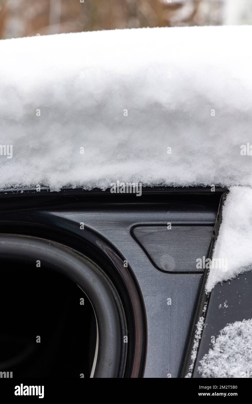 Eine dicke Schicht frischen Schnees auf dem Dach eines Pkw. Starker Schneefall erschwert Fahrern das Leben. Stockfoto