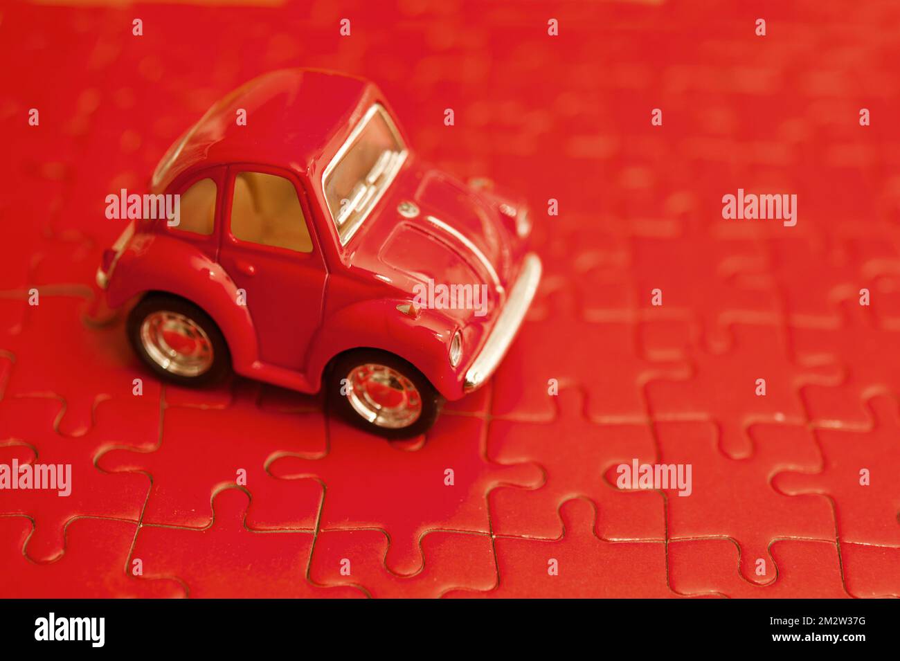 Rotes Spielzeugmodell auf einem Puzzle Stockfoto