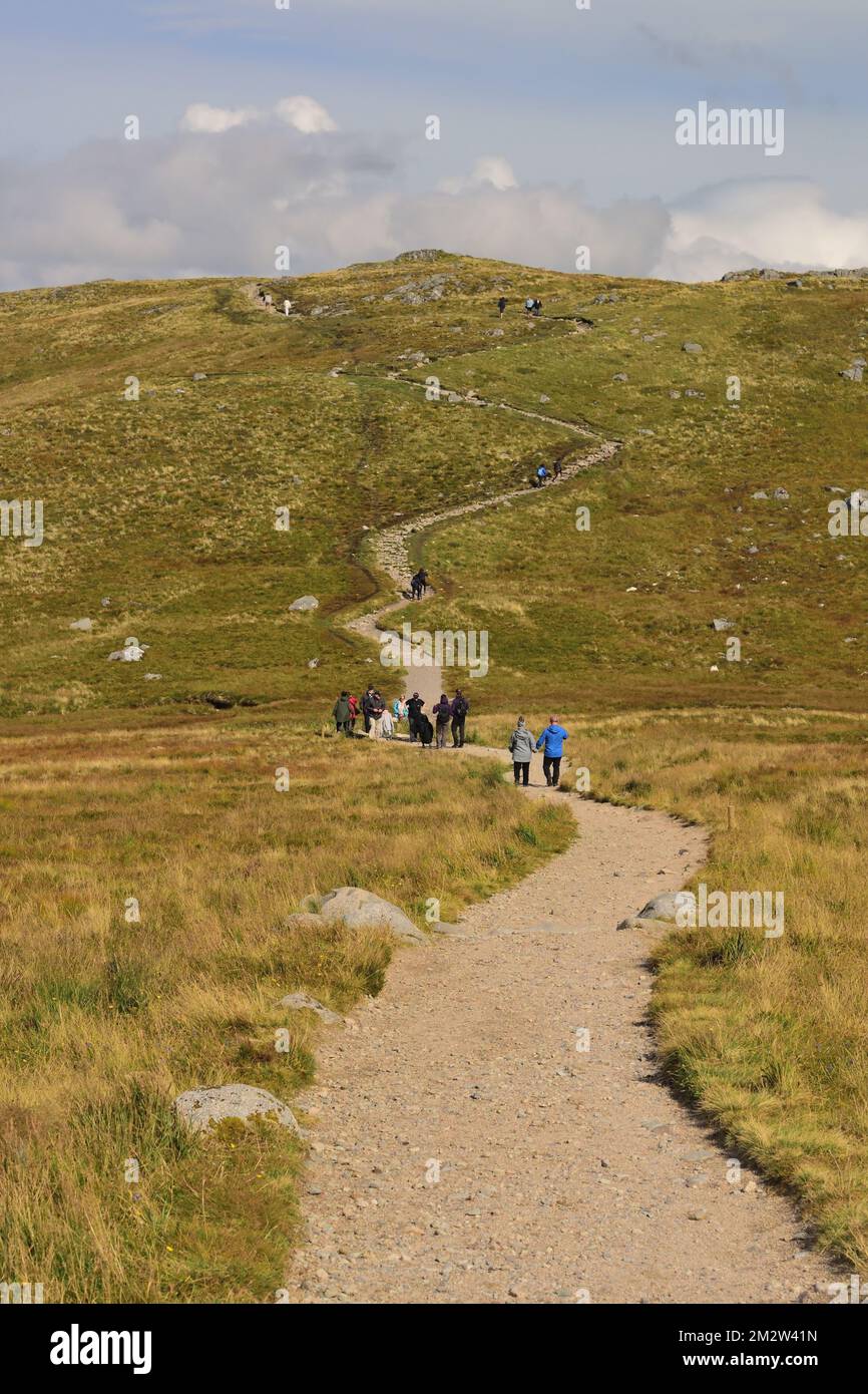 Menschen, die auf dem Bergpfad zum Sgurr Finnisg-aig Aussichtspunkt am Nevis Range auf Aonach Mor, Scottish Highlands, spazieren gehen. Stockfoto