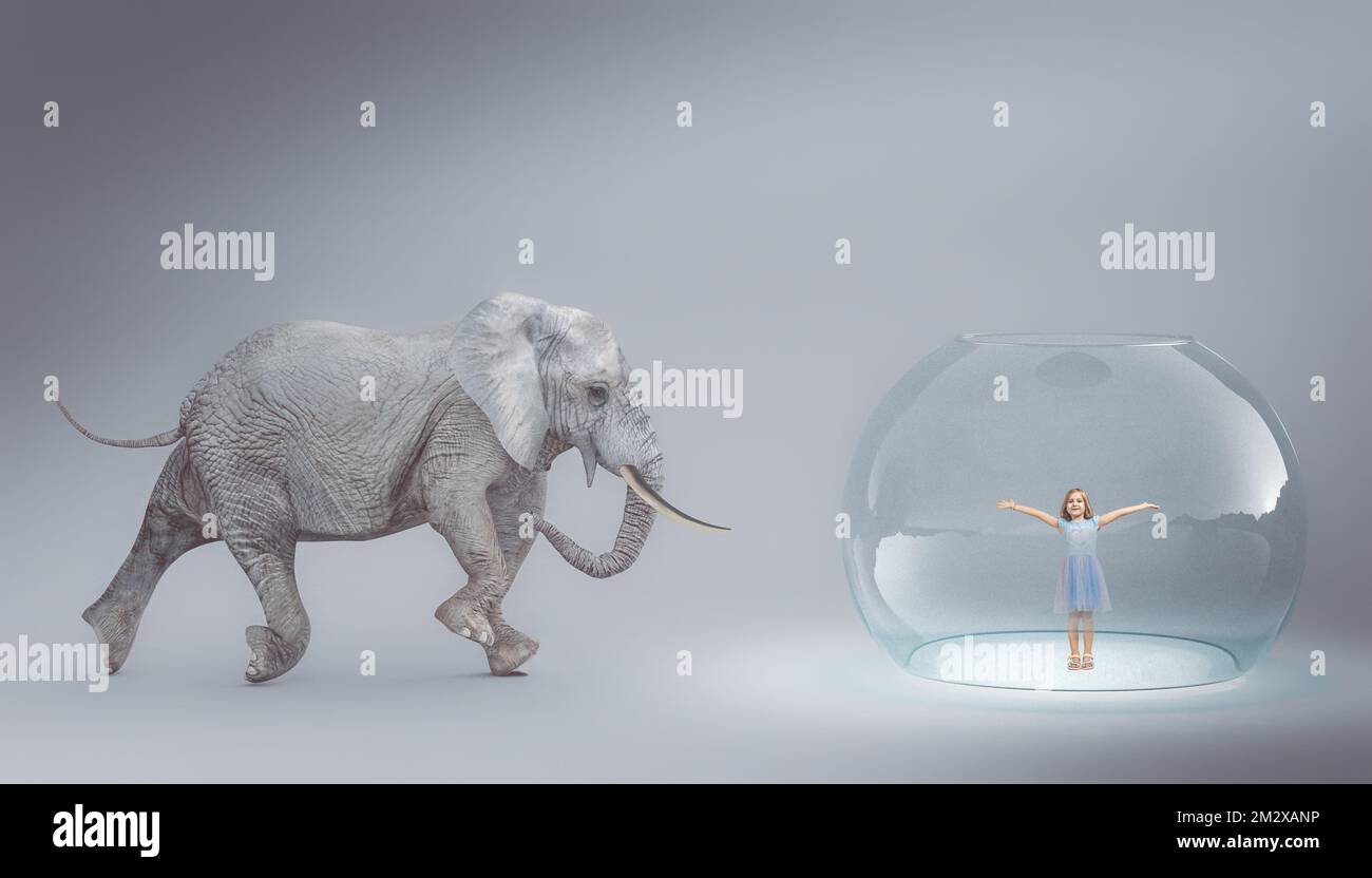 Ein großer Elefant, der auf eine Glasblase zugeht, mit einem lächelnden kleinen Mädchen drinnen Stockfoto