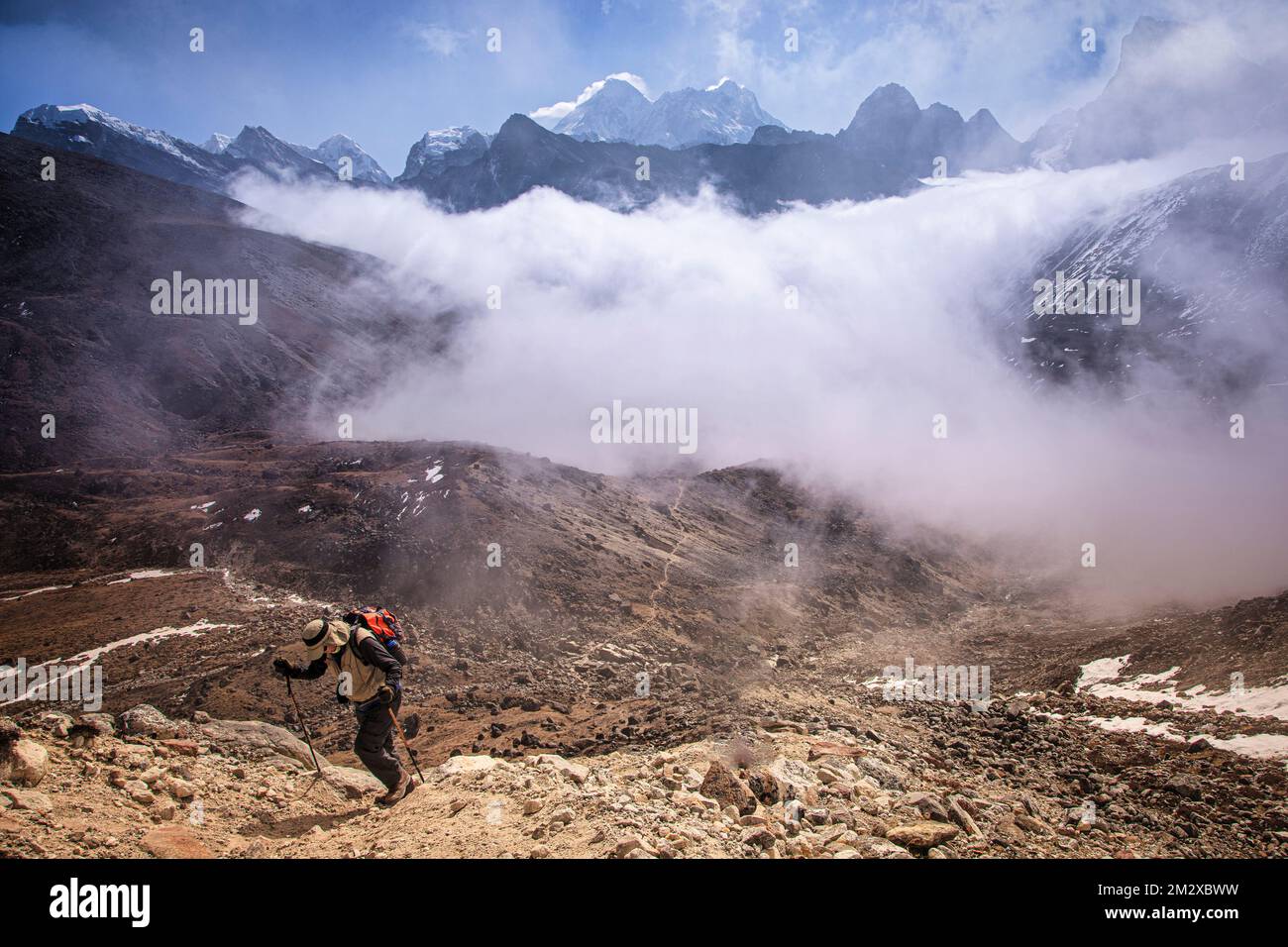 Klettern Sie zum Renjo La (Pass) in 18.000 Fuß Höhe, während Wolken den Gokyo Lake bedecken, aber erlauben Sie entfernte Blicke auf Mount Everest, Nuptse und Lhotse. Stockfoto