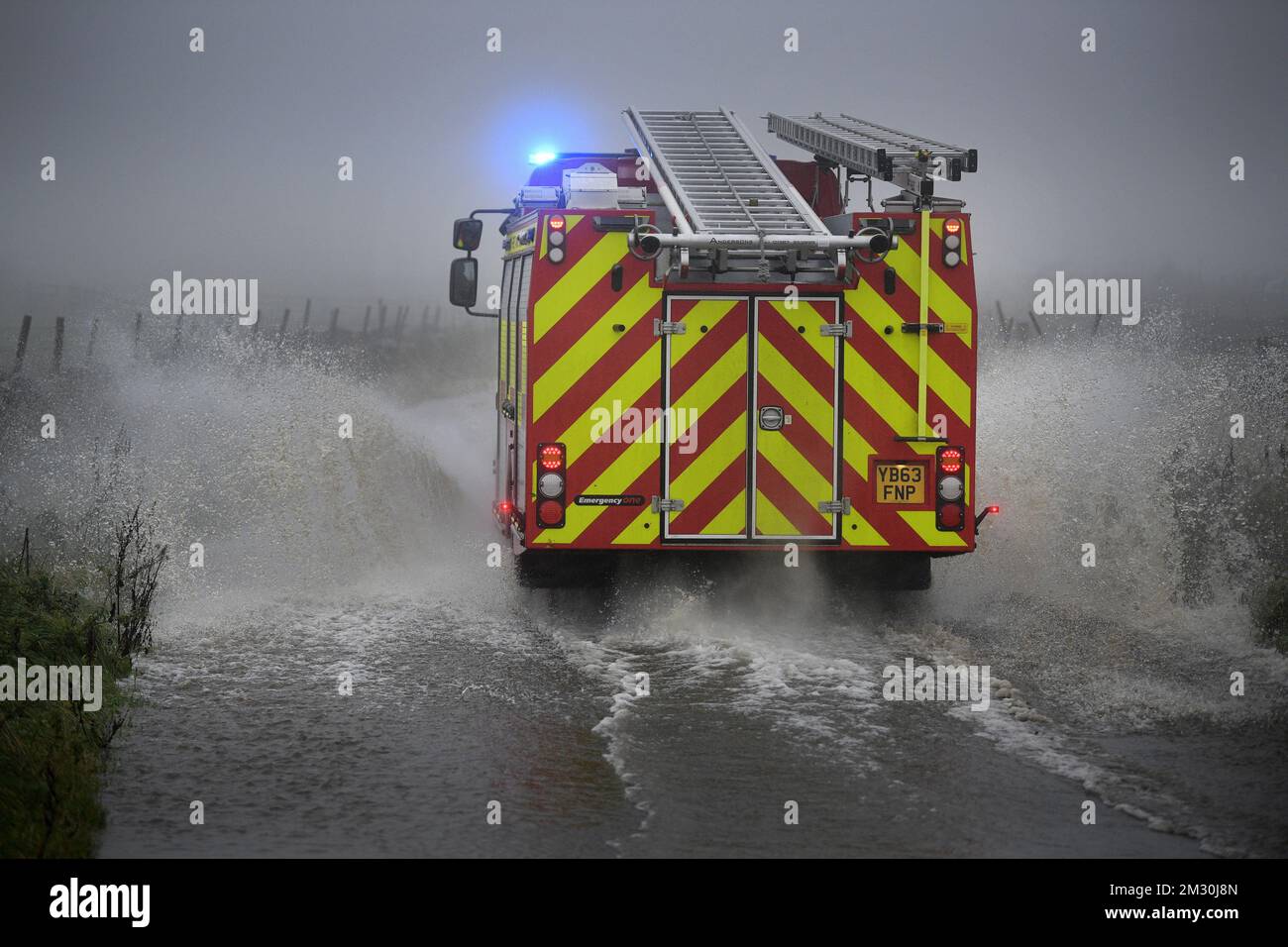Die Abbildung zeigt einen Feuerwehrwagen, der während des Herrenrenrenrenrenrenlaufs bei der UCI Road World Championships am Sonntag, den 29. September 2019, in Harrogate, North Yorkshire, Großbritannien, durch den Regen und eine riesige Pfütze fährt. Die Welten finden vom 21. Bis 29. September statt. BELGA FOTO YORICK JANSENS Stockfoto