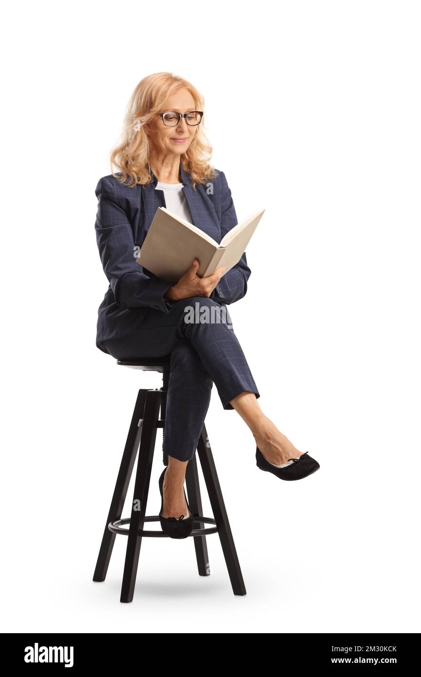 Professionelle Frau, die auf einem Stuhl sitzt und ein Buch liest, isoliert auf weißem Hintergrund Stockfoto