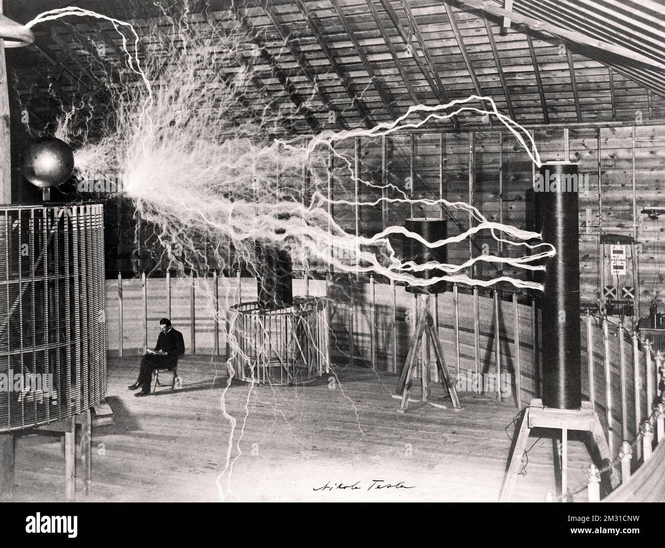 Nikola Tesla erzeugt mit seiner Ausrüstung zur Erzeugung von Hochfrequenz-Wechselströmen in seinem Labor in Colorado Springs künstliche „Blitze“. Datum: 1899-1900. Nikola Tesla war ein serbisch-amerikanischer Erfinder, Elektroingenieur, Maschinenbauingenieur und Zukunftswissenschaftler, der am besten für seinen Beitrag zur Entwicklung des modernen Wechselstromsystems bekannt ist. Eine optimierte Version eines Originalfotos. Stockfoto