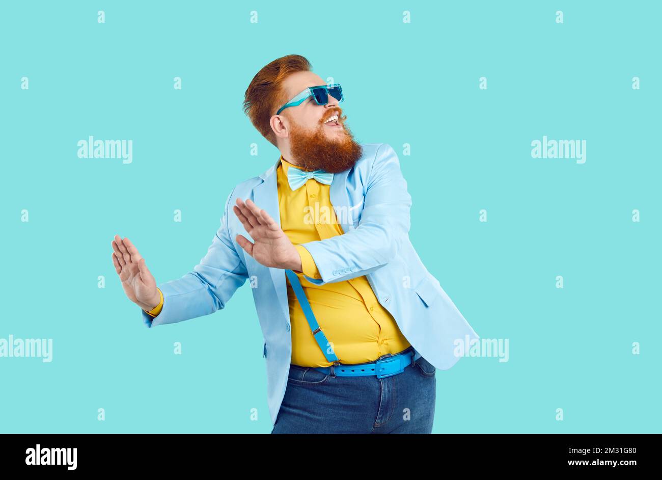Cool, fröhlich, stylischer fetter Mann freut sich und lustige Tänze isoliert auf hellblauem Hintergrund. Stockfoto