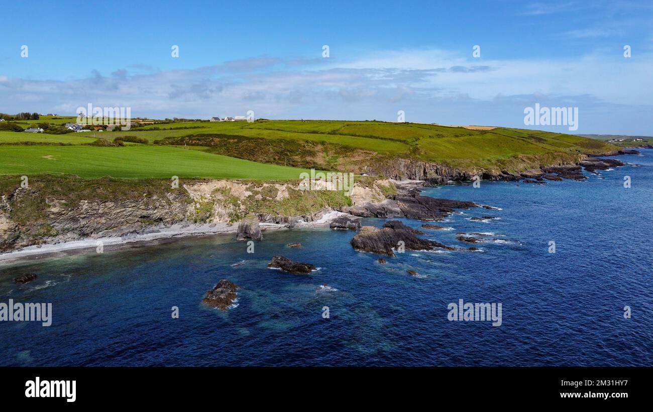 Grüne Hügel am Atlantik an einem sonnigen Frühlingstag. Blauer Himmel über der Küste. Die Küste Irlands, West Cork. Drohnenfoto. Stockfoto