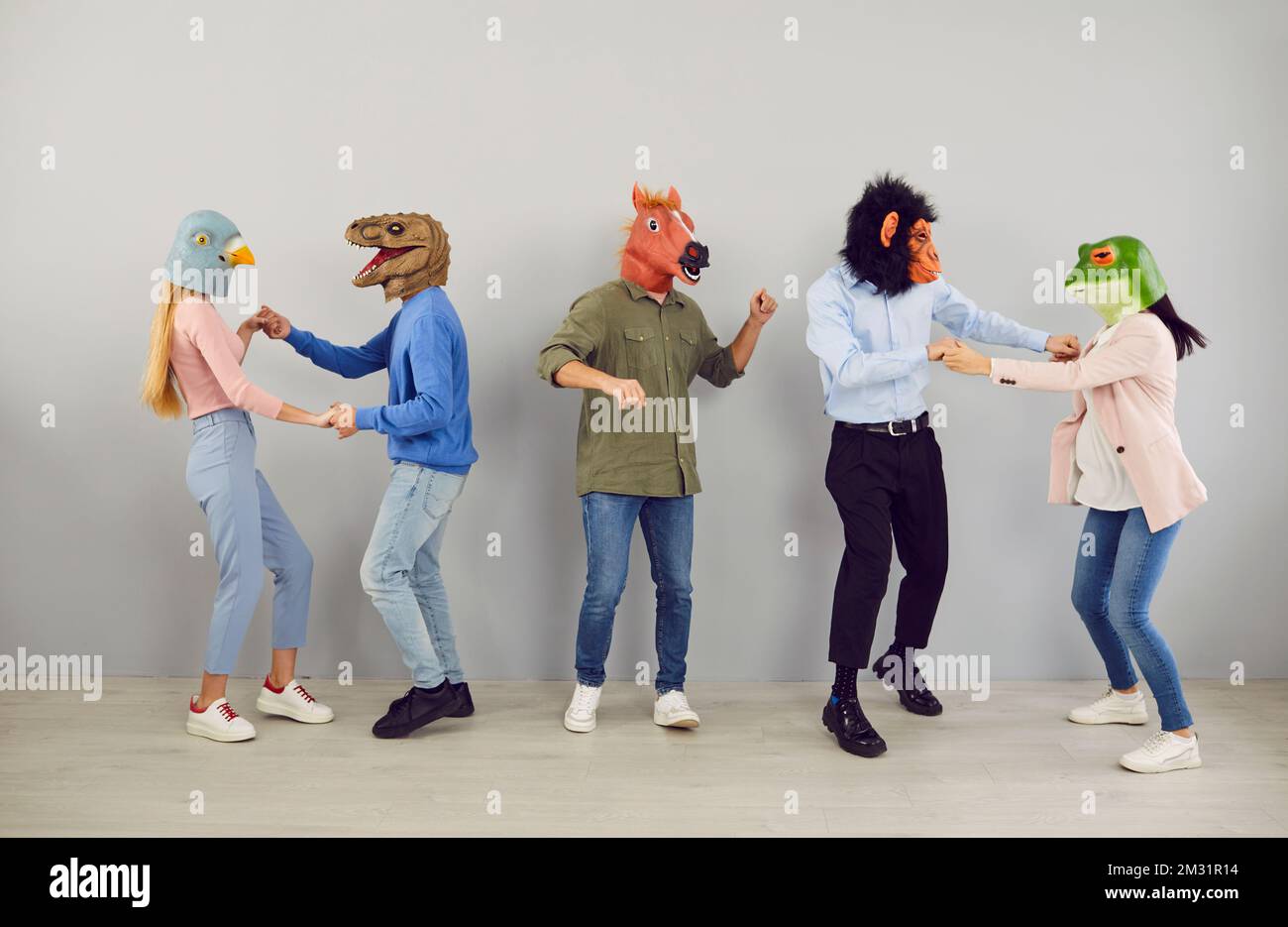 Eine Gruppe seltsamer junger Menschen in lustigen Tiermasken, die tanzen und Spaß auf einer verrückten Party haben Stockfoto