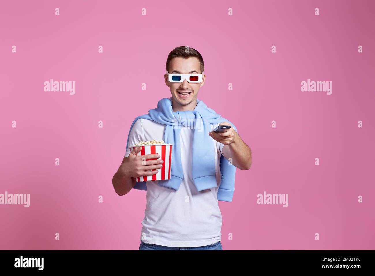 Ein Mann mit Fernbedienung und einem großen Eimer Popcorns Stockfoto