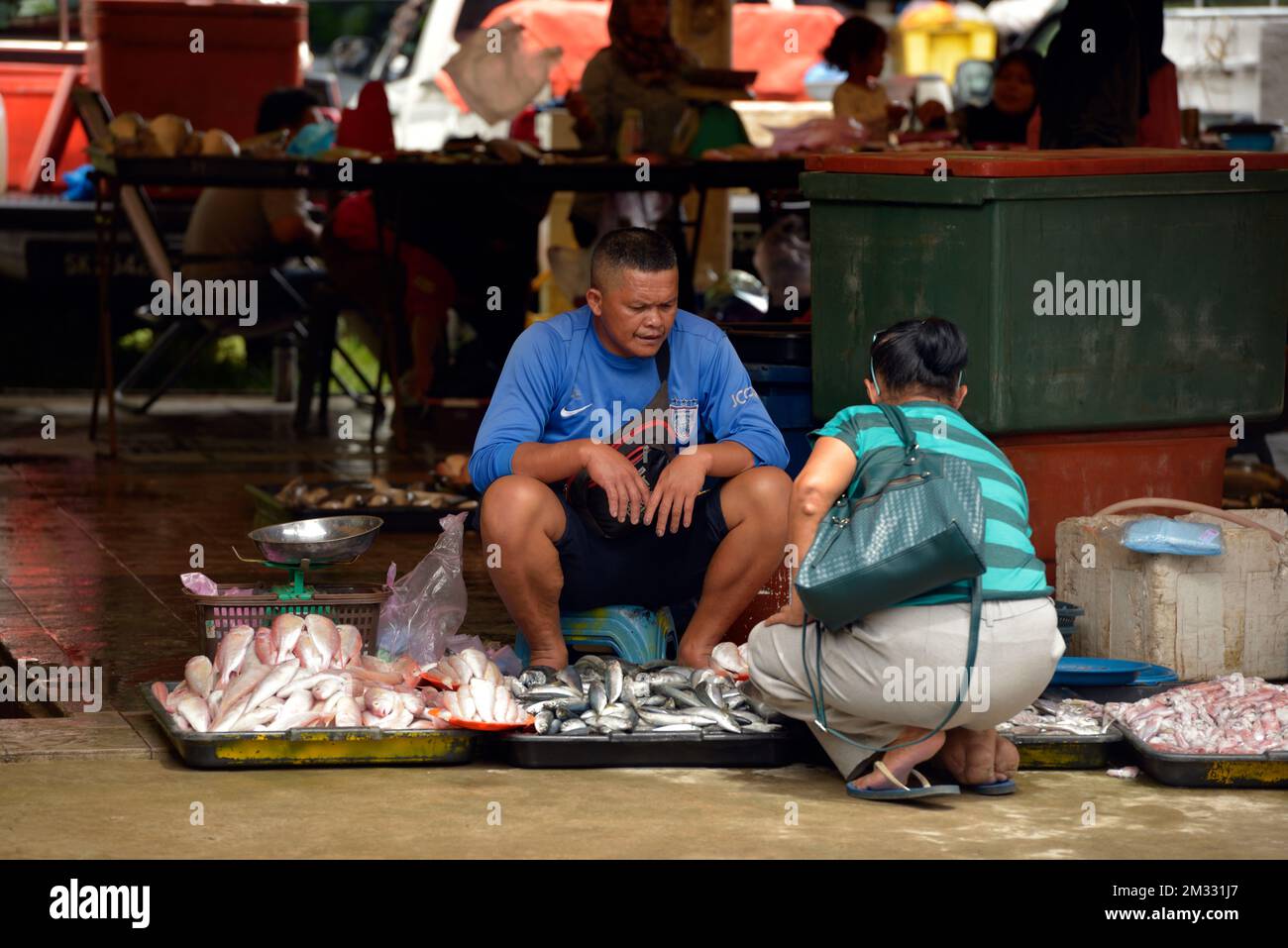 Ein Mann, der Fisch auf dem Sonntagsmarkt (Tamu) in Kota Belud, Sabah, Borneo, Malaysia verkauft. Stockfoto