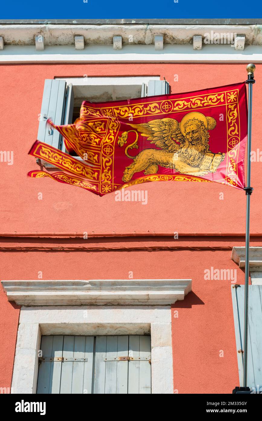 Löwenflagge von Venedig, Blick auf eine Flagge des Löwen des Heiligen Markus - Wahrzeichen der Stadt und der Comune von Venedig - in einer Straße auf der venezianischen Insel Chioggia Stockfoto