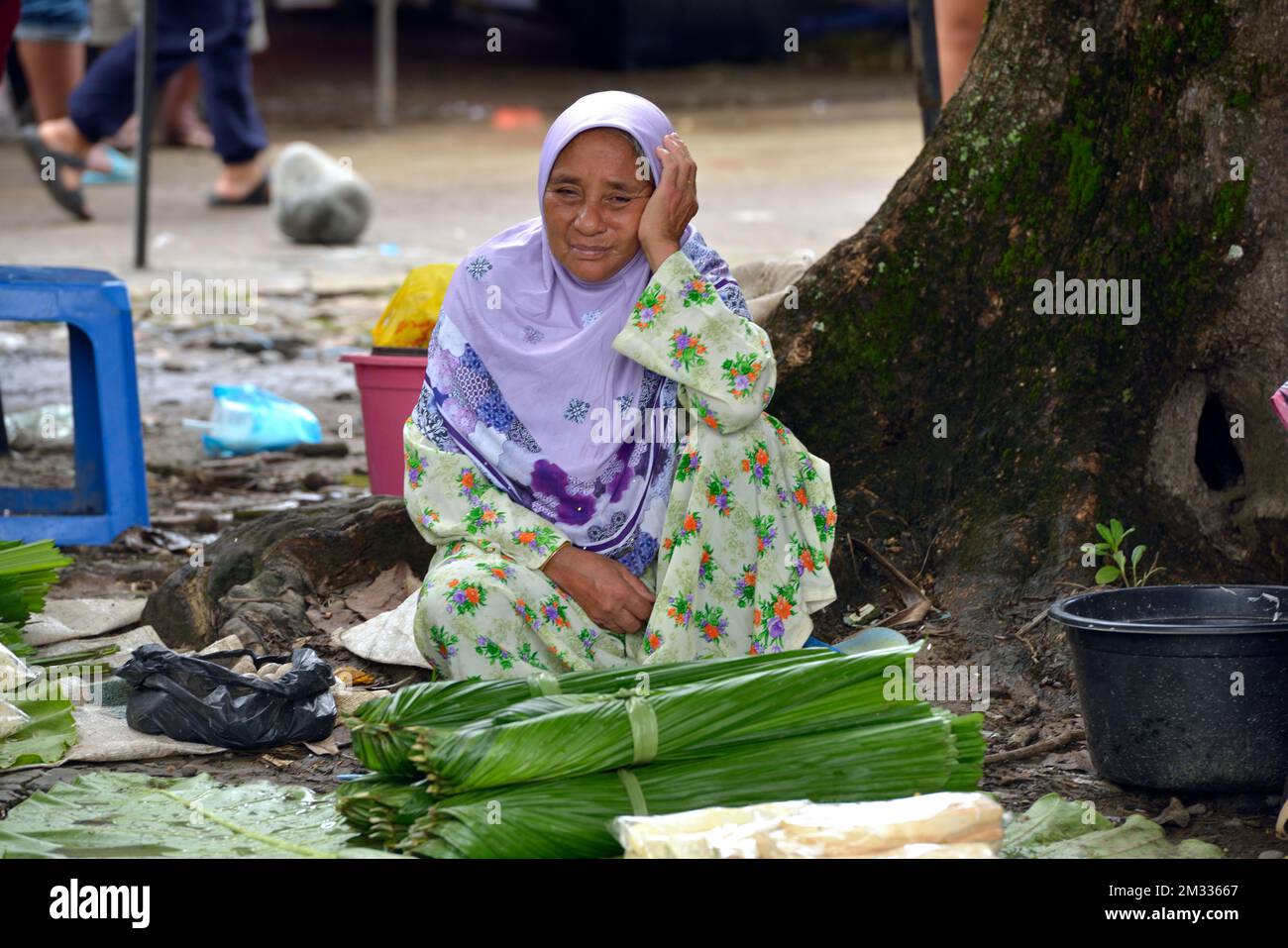 Eine einheimische Bajau-Frau, die auf dem Sonntagsmarkt (Tamu) in Kota Belud, Sabah, Borneo, Malaysia Lebensmittel verkauft. Stockfoto