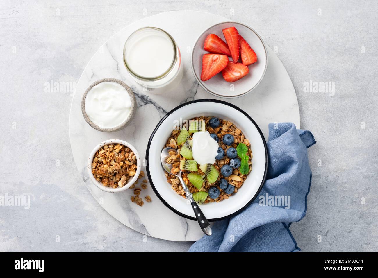 Müsli mit Obst und Joghurt in einer Schüssel. Tabellenansicht. Süße Frühstückszerealien Stockfoto