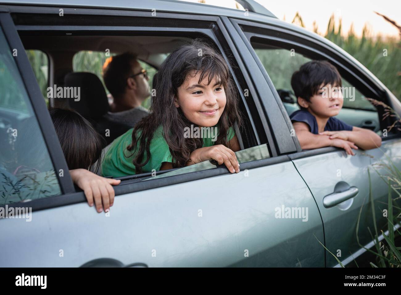 Zwei Mädchen, die von den Autofenstern der Familie aus zusehen Stockfoto