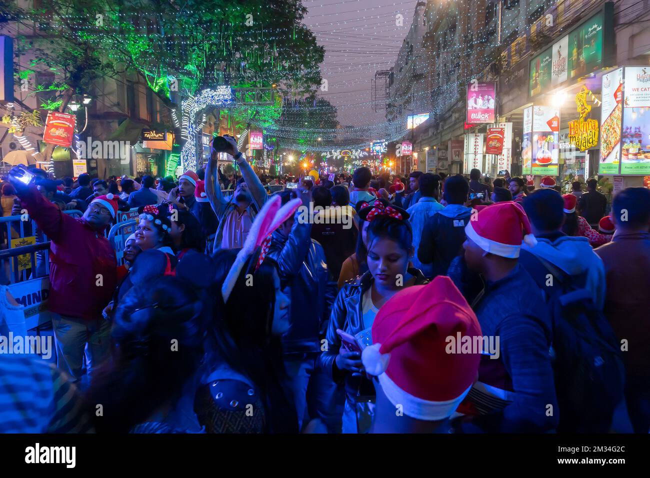Kalkutta, Westbengalen, Indien - 26.12.2018 : Junge und Mädchen feiern Weihnachten in einer beleuchteten und dekorierten Parkstraße mit Lichtern und Jahreszeit Stockfoto