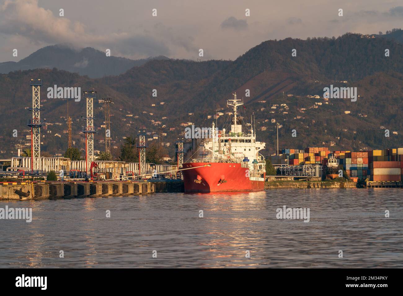 Rotes Tankschiff im Terminal-Hafen. Transport, Logistik und Entladung von Gas oder Öl im Industriehafen. Stockfoto