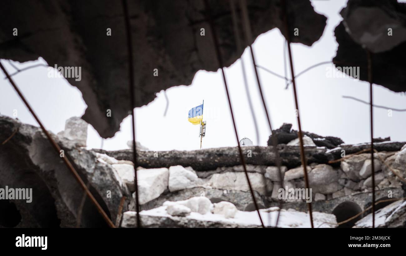 Ukrainische Flagge vom Bruch im Dach der zerstörten Schule, die die russischen Bewohner als Hauptquartier benutzten Stockfoto