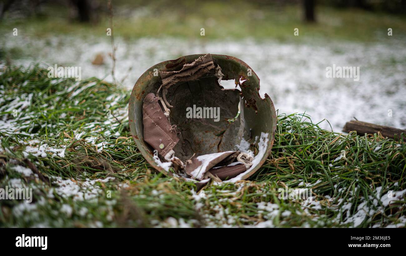 Ein russischer Militärhelm aus der Zeit des Zweiten Weltkriegs auf dem schneebedeckten Gras in einem frei besetzten Dorf in der Oblast Kherson, Ukraine Stockfoto