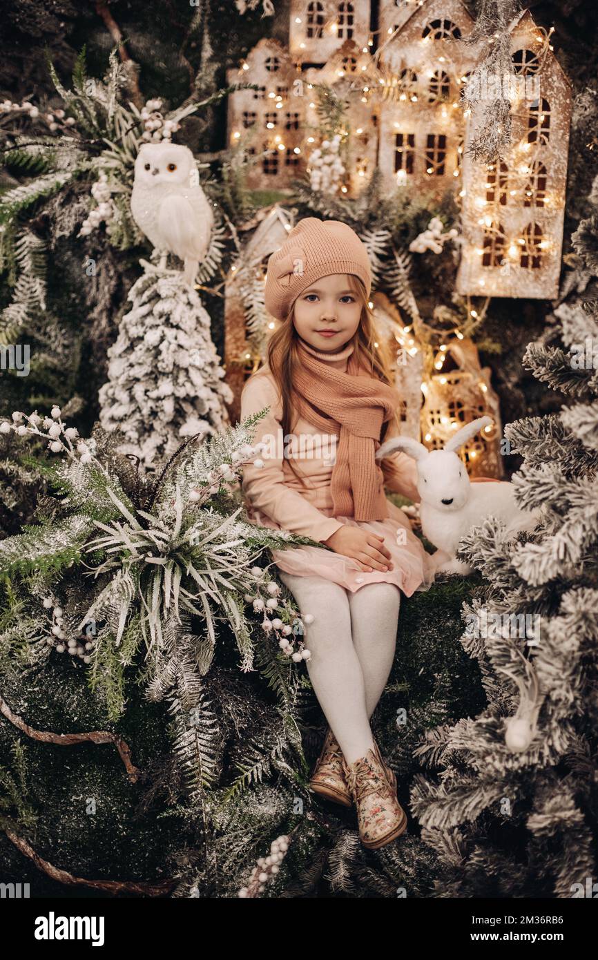 Süßes Mädchen mit Hut und Schal in Weihnachtsdekorationen. Stockfoto
