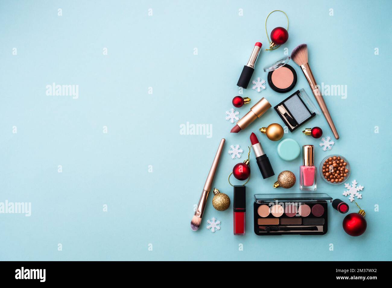 Weihnachtsbaum aus Kosmetik- und Make-up-Produkten auf Blau. Stockfoto
