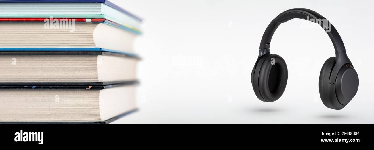 Hörbücher. Hörbuchkonzept, Bücherstapel und Kopfhörer mit Platz für Kopien. Auswahl zwischen Büchern und Audio. Stockfoto