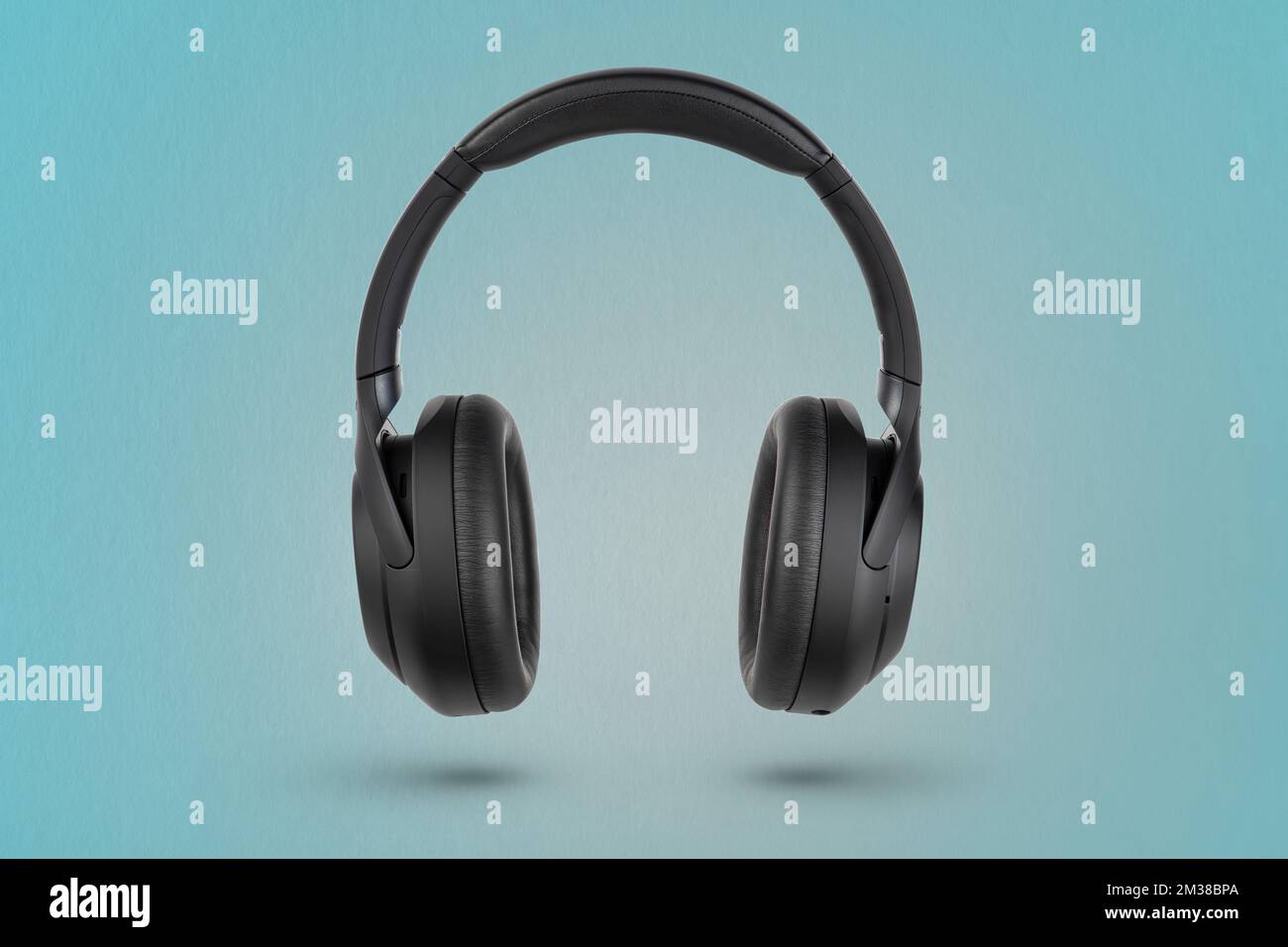 Kopfhörer auf blauem Hintergrund. Kabellose Kopfhörer in Schwarz, hohe Qualität, für Werbung oder Produktkatalog. Stockfoto