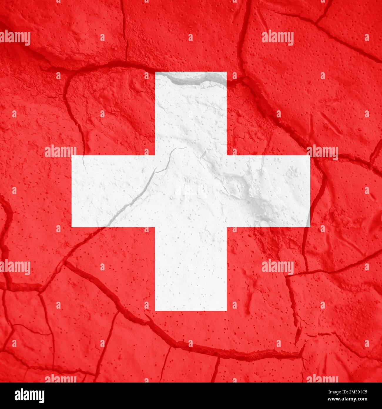 Schweizer Flagge. Schweizer Symbol. Flagge auf dem Hintergrund von trockener, gerissener Erde. Schweizer Flagge mit Dürrekonzept Stockfoto