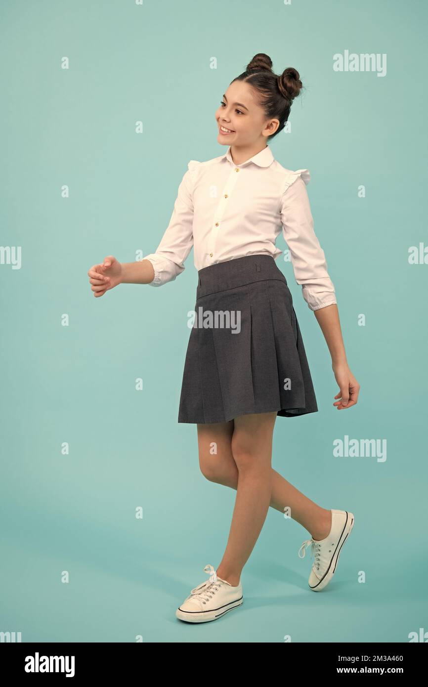 In voller Länge Foto von brünett teen Mädchen tragen Casual Shirt und Rock auf blauem Hintergrund isoliert. Glücklicher Teenager, positive und lächelnde Emotionen des Teenagers Stockfoto