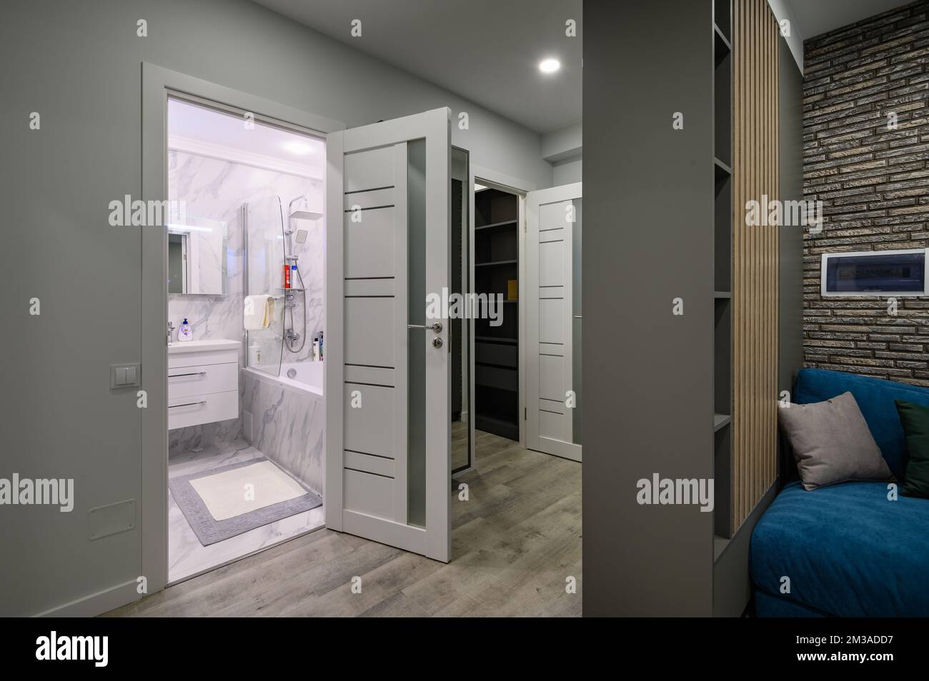 Die Eingangshalle ist an ein kleines modernes Wohnzimmer angeschlossen Stockfoto