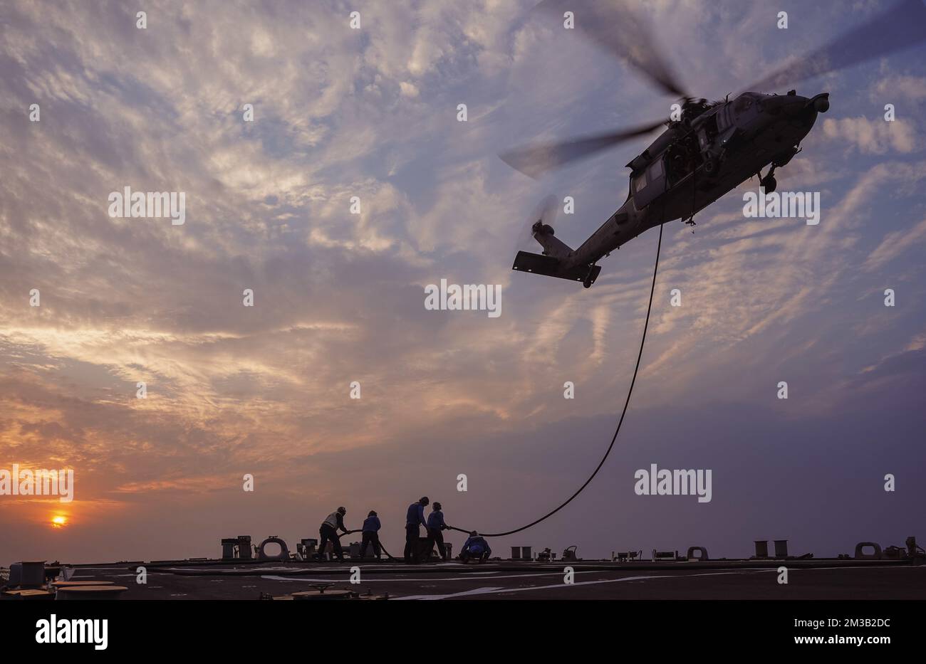 221207-N-EB711-1015 ARABISCHER GOLF (7. Dez. 2022) Geführte Raketenzerstörerin USS die Sullivans (DDG 68) führt Hubschrauberbetankungen während des Fluges mit einem MH-60R Sea Hawk Helikopter durch, der dem Helicopter Sea Combat Squadron (HSC) 26, Einheit 1, im Arabischen Golf, Dez. 7, zugewiesen ist. Die Sullivans werden im US-Flottengebiet 5. eingesetzt, um die Sicherheit und Stabilität der Seeschifffahrt im Nahen Osten zu gewährleisten. (USA Marinebild von Sonar Technician (Surface) 1. Class Kevin FRUs) Stockfoto