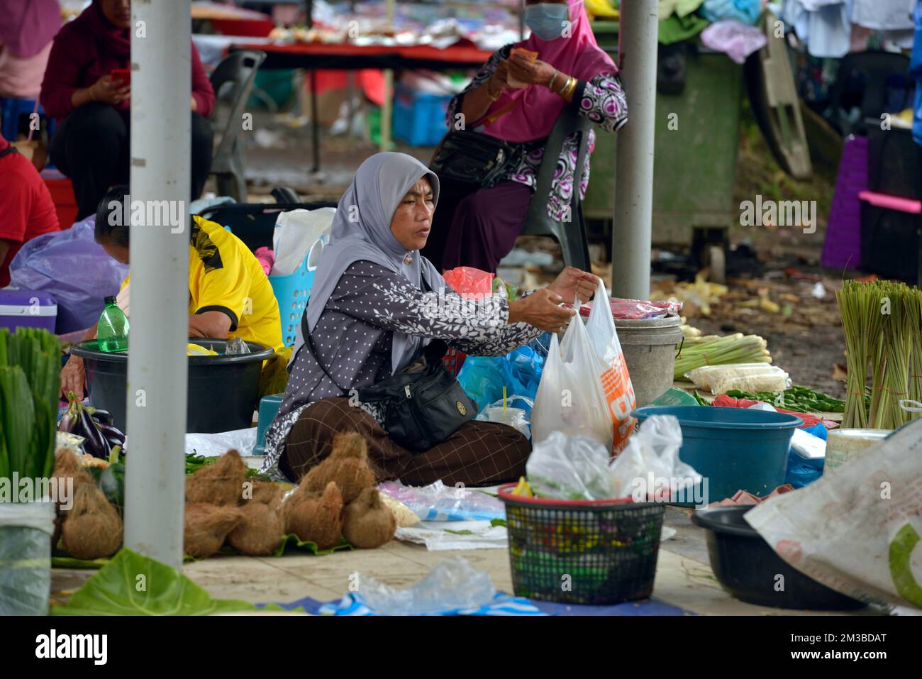 Eine einheimische Bajau-Frau, die Essen auf dem Sonntagsmarkt in Kota Belud, Sabah, Borneo, Malaysia verkauft. Stockfoto